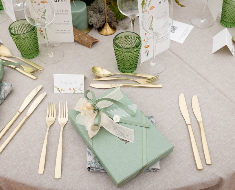 a table setting with a gift wrapped in a gift box
