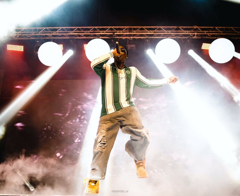Stonebwoy in tattered jeans performing on stage.