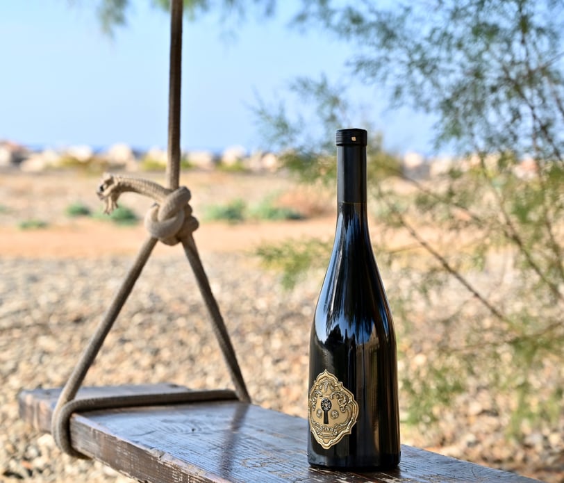 a bottle of daskali's wine on a wooden bench