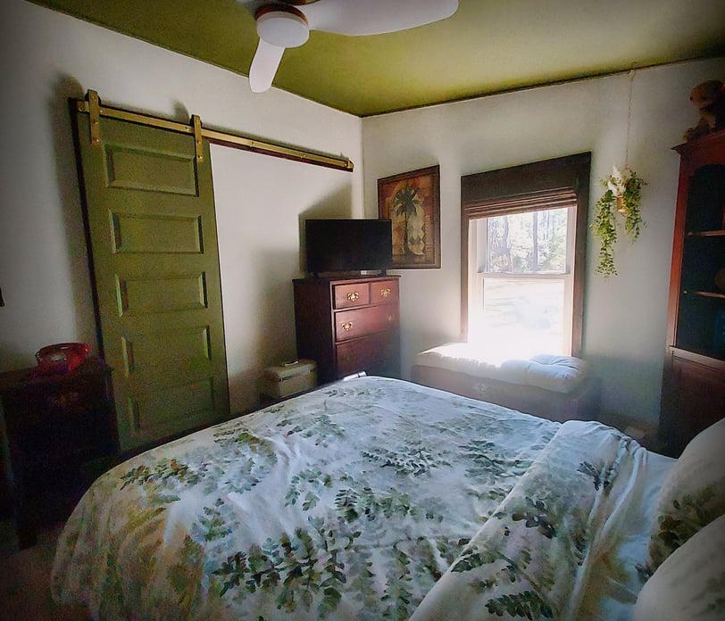 a bedroom with a bed and a television