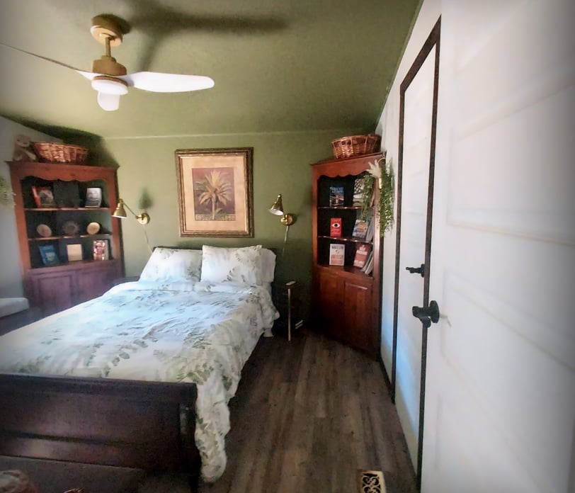 a bedroom with a bed and a wooden floor