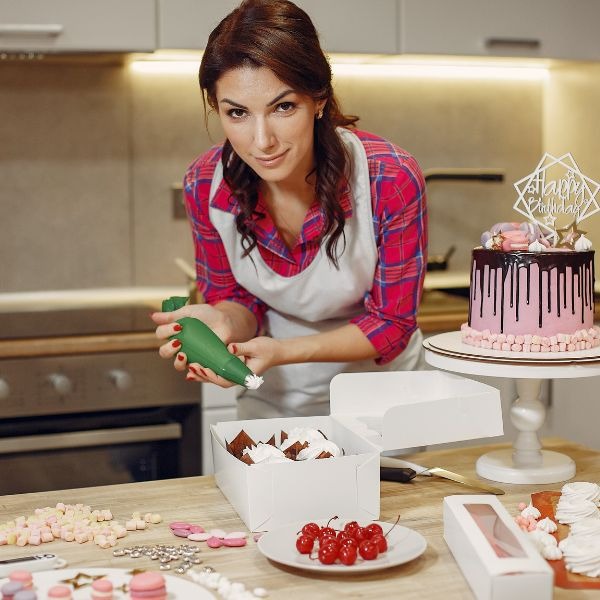 a woman in a apron is making cupcakes