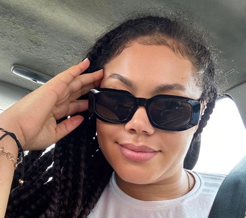 Nadia Buari in a white shirt with black sunglasses on.