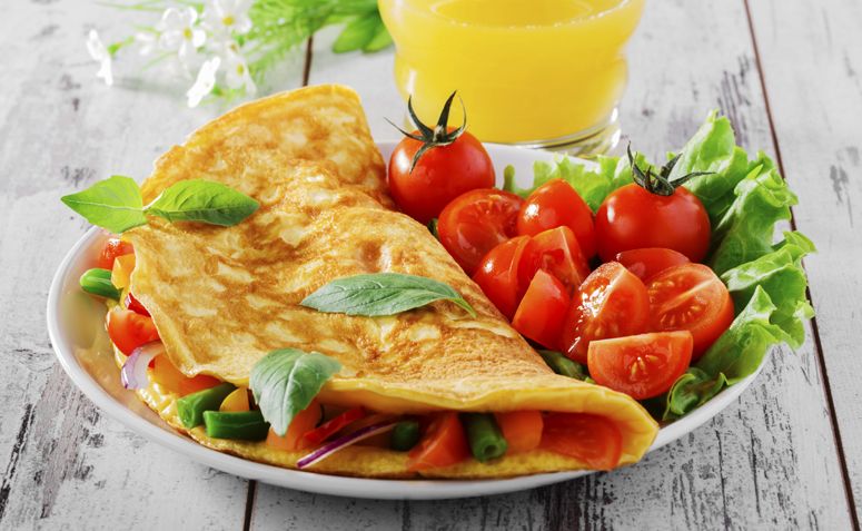 Deliciosa omelete dourada, recheada e servida quente, pronta para servir.