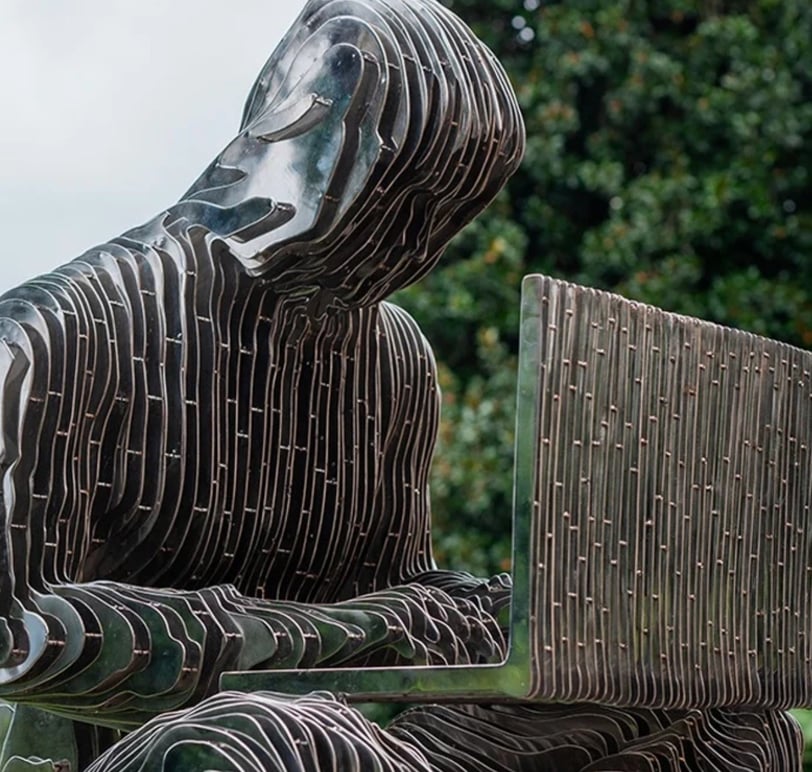 a statue of a man sitting on a bench