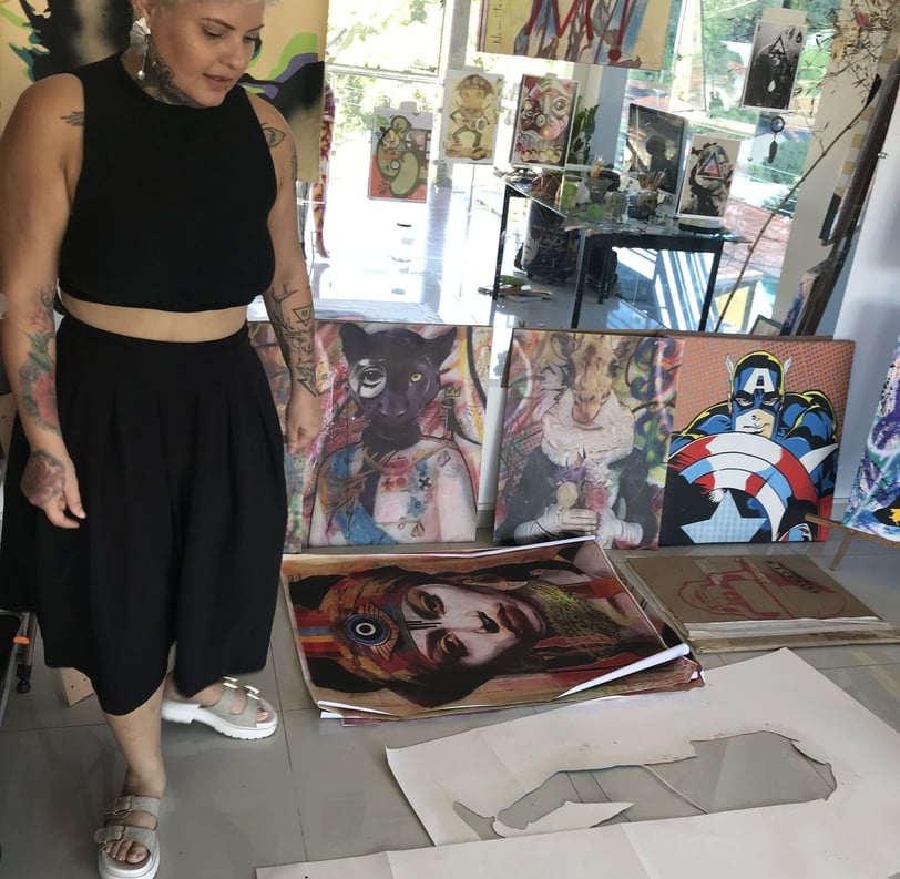 Amanda Amorim aplica spray em uma tela, criando uma obra com temas indígenas.