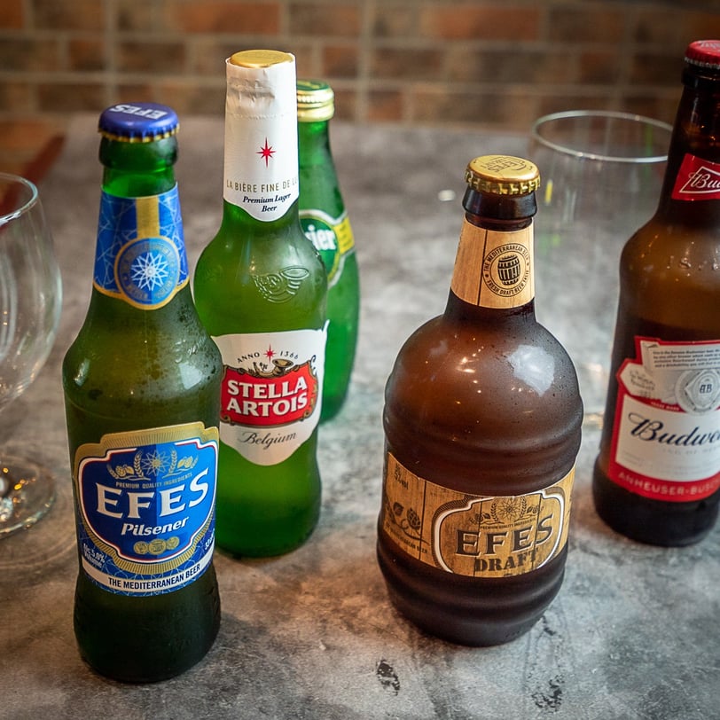 a variety of beer bottles and glasses on a table