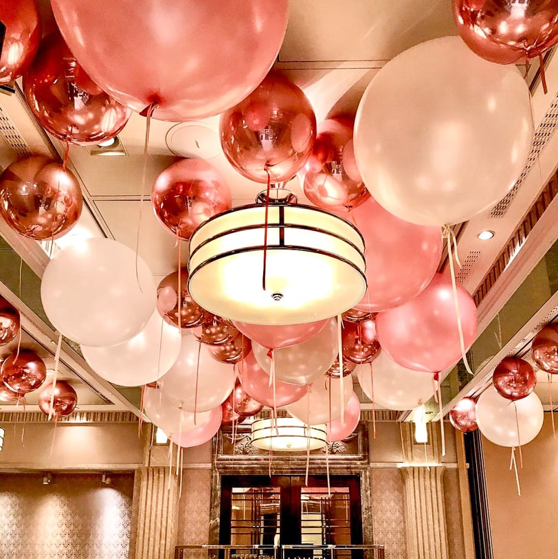 Festive balloon ceiling decor with pastel and metallic balloons for a 1st birthday celebration.