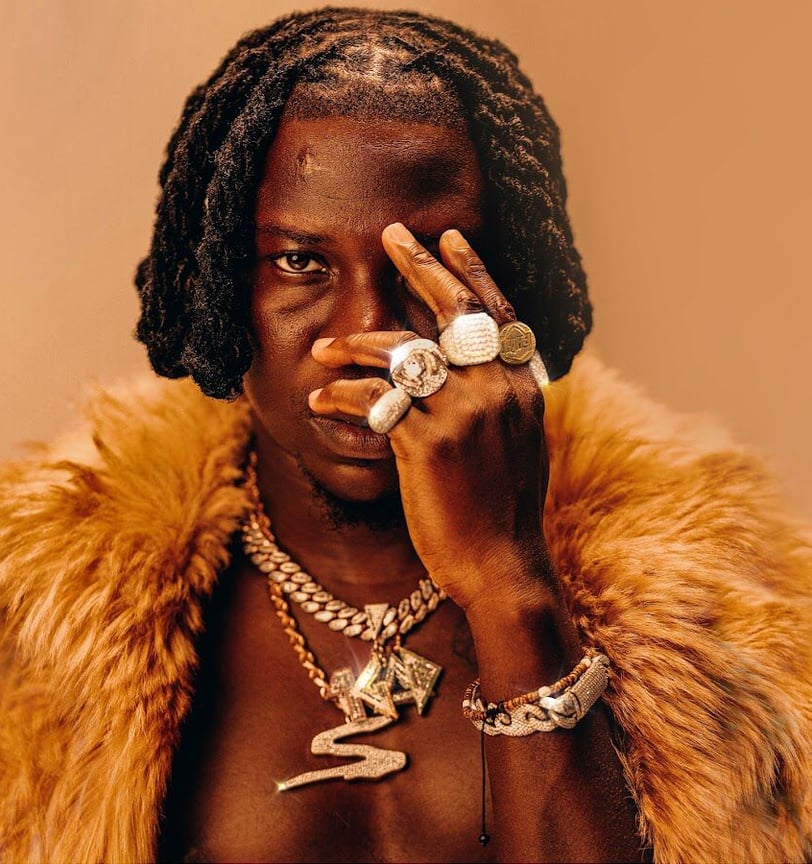 Stonebwoy with animal fur around his neck.