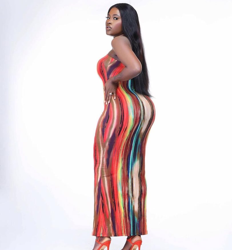 Fella Makafui in a multi-colored straight dress.