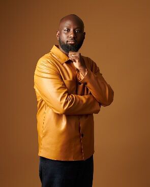 Kofi Karikari in a brown leather shirt.