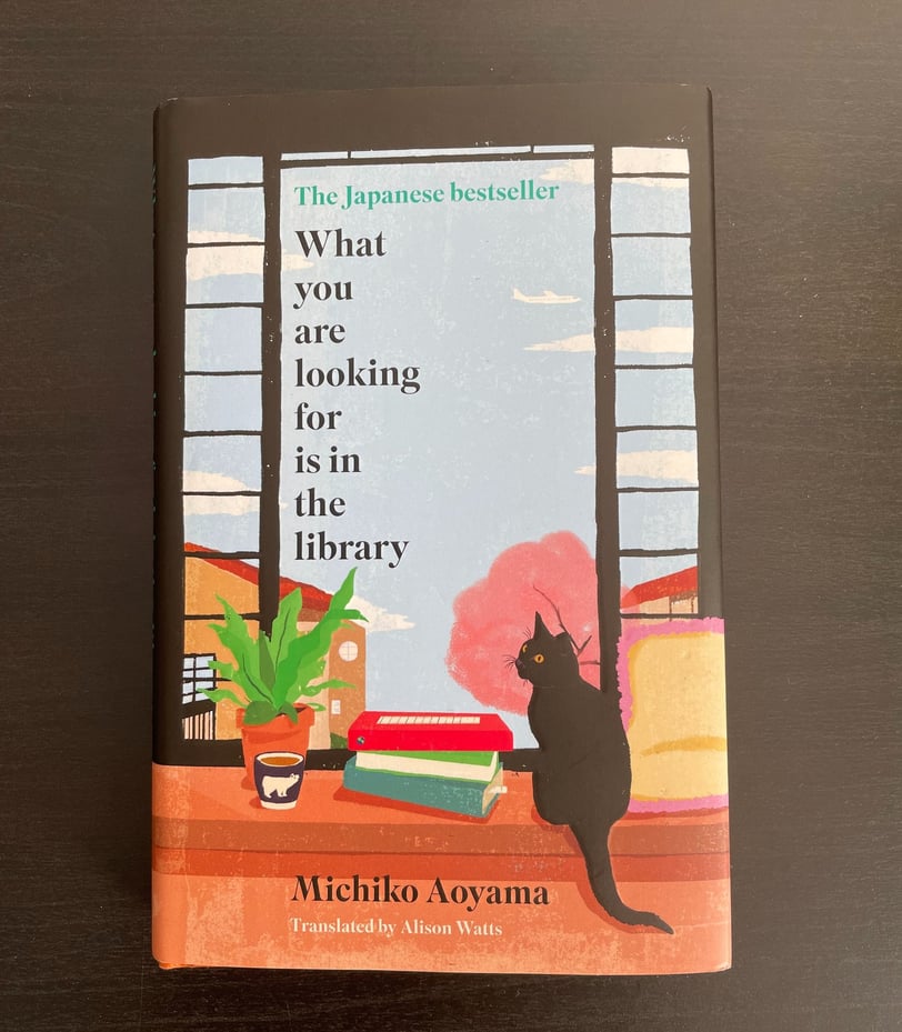 a book with a cat sitting on a table. What you are looking for is in the library