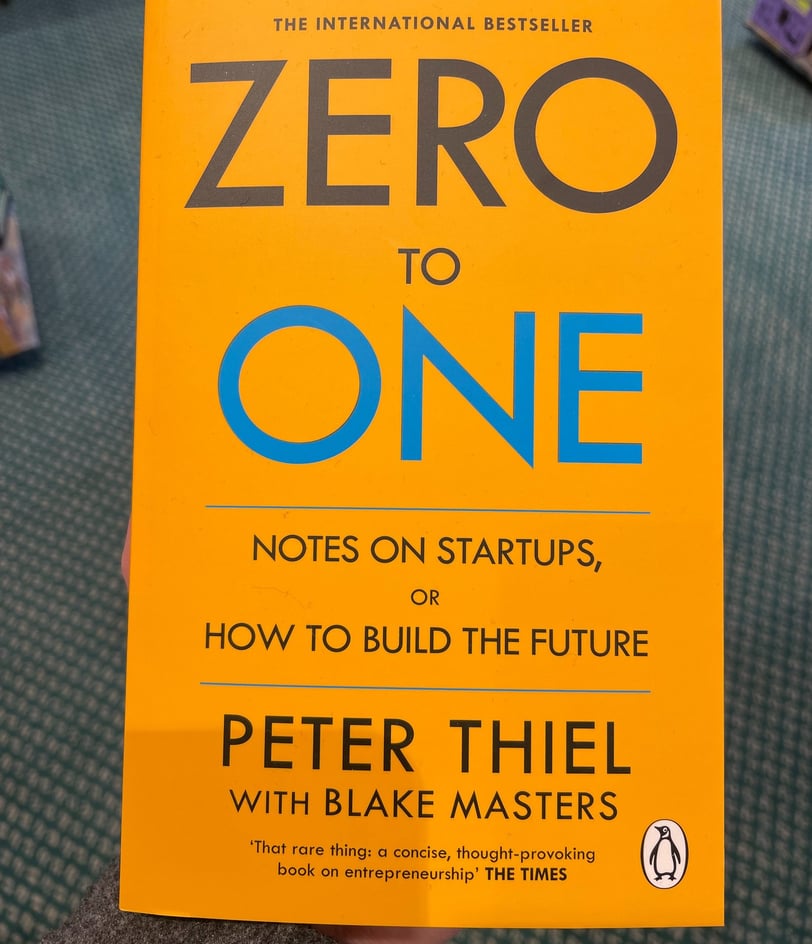 a person holding a book about zero to one