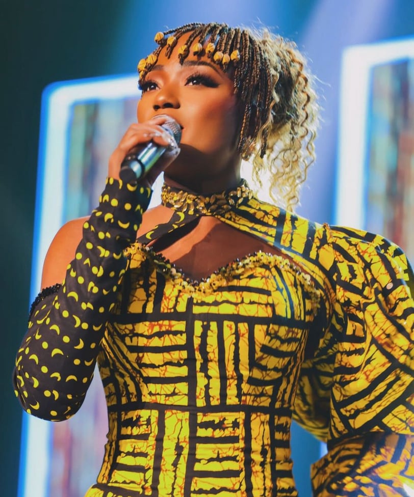 Efya Nocturnal in an African print on stage.