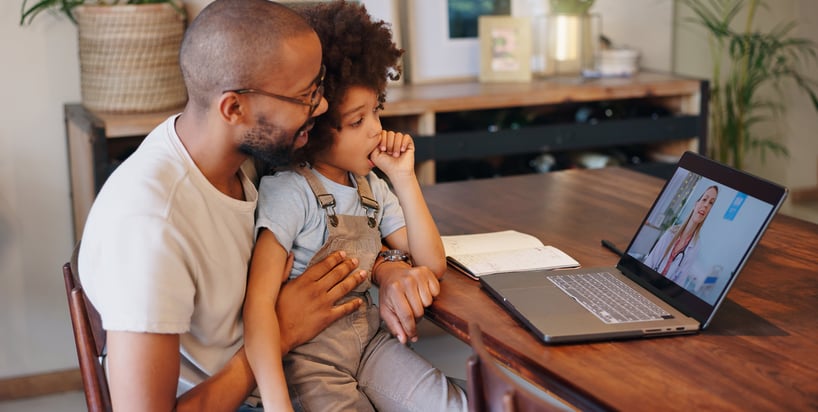 father and child talking to a health practitioner via telehealth