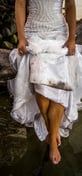 Robe de mariée sale et mouillée Trash The Dress sur une branche au bord de l'eau
