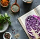 a cabbage, a cook book with spices and some parsley