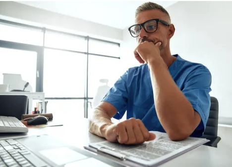 a man sitting at a desk with a keyboard and a computer