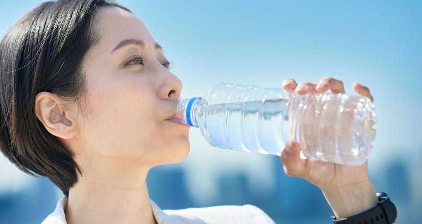 woman drinking water out of a bottle