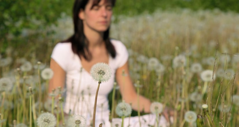 woman sitting in a field in silence