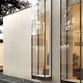 Fachada arquitectónica revestida en madera y vidrio, con cerramientos móviles para regular luz y privacidad