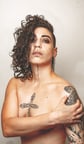 a woman with tattoos on her posing for a photo