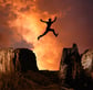 Silhouette jumping over rocks, representing breaking through personal barriers