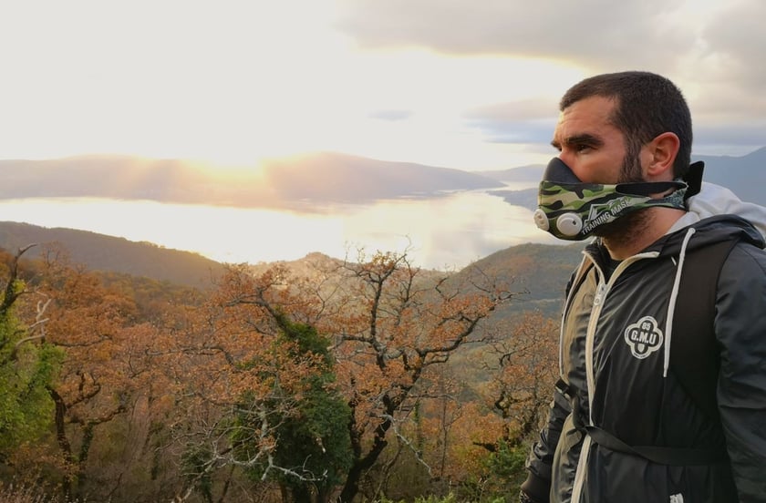 a man wearing a mask and a mask on a mountain