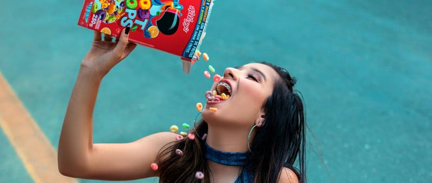 Woman ignoring the conneciton between mood and her diet as she chows down froot loops all over her