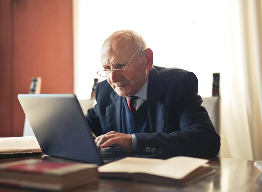 a man in a suit and tie is sitting at a desk