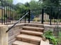 outdoor staircase with metal handrails and fence