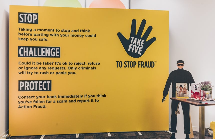 a cardboard thief standing in front of a large yellow banner