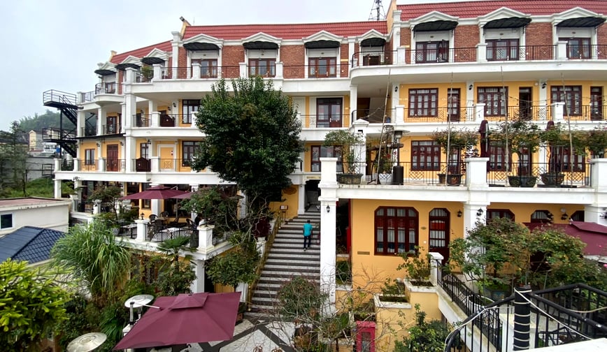 a building with a staircase leading to a building with a red roof