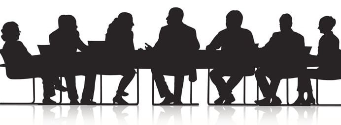 Silouhettes of people sitting at a conference table