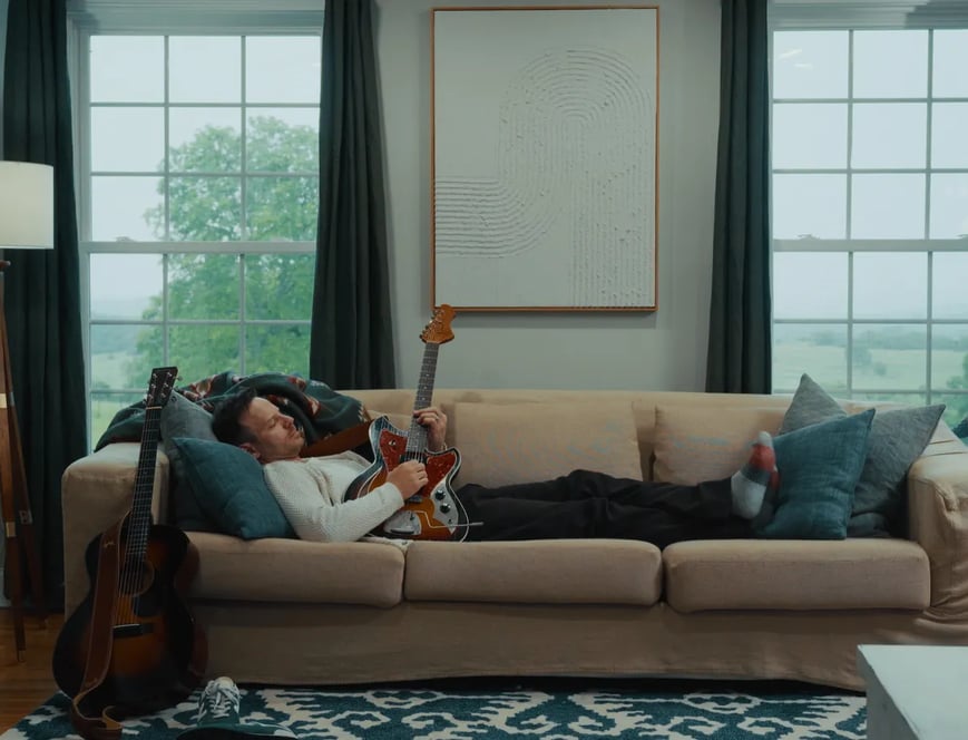 a man laying on a couch in a living room