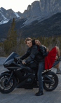 a man and woman sitting on a motorcycle during their photoshoot in Canmore