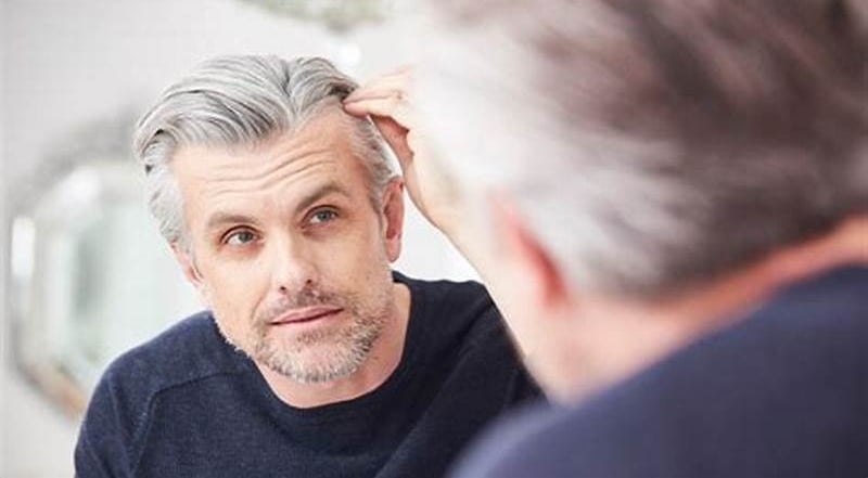 hombre mirándose al espejo las canas