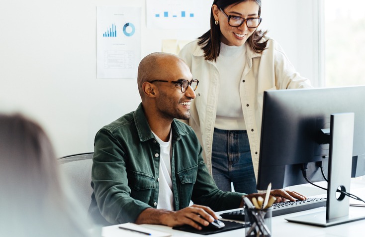 a man and woman working on a computer