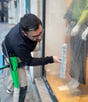 Technicien de M & M Services Pro nettoyant la vitrine du magasin Léo et Ugo à Rouen