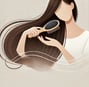 a woman with long hair and a brush in her hand