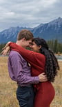 a man and woman standing in a field in Banff