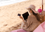 Mujer en playa con tarjeta