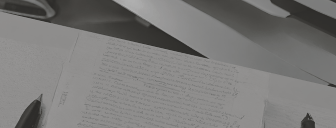 Un ordinateur, un manuscrit et un stylo