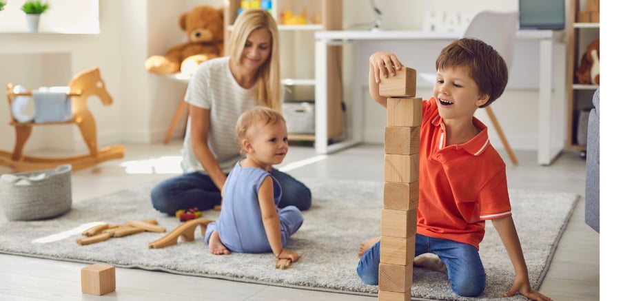Mum and two young children playing with toys on the floor 