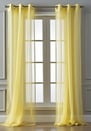 Pair of sheer yellow curtains hanging from a grommet rod over a window.