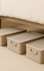 Three rectangular fabric bins with clear lids neatly tucked under a bed for smart, hidden storage.