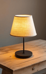 A sleek, modern cordless lamp with a warm glow rests on a small table.
