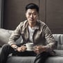 a man sitting on a couch with a cup of coffee