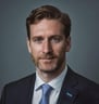 a man in a suit and tie with a blue tie