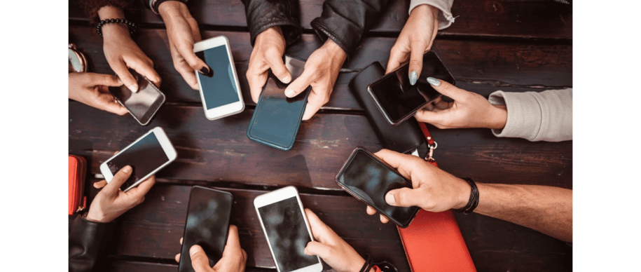 Group of people using smartphones at a table | Social media engagement and digital communication